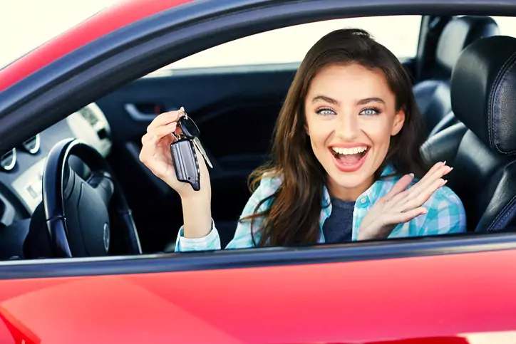 Women in red car with keys Happy woman in a new car